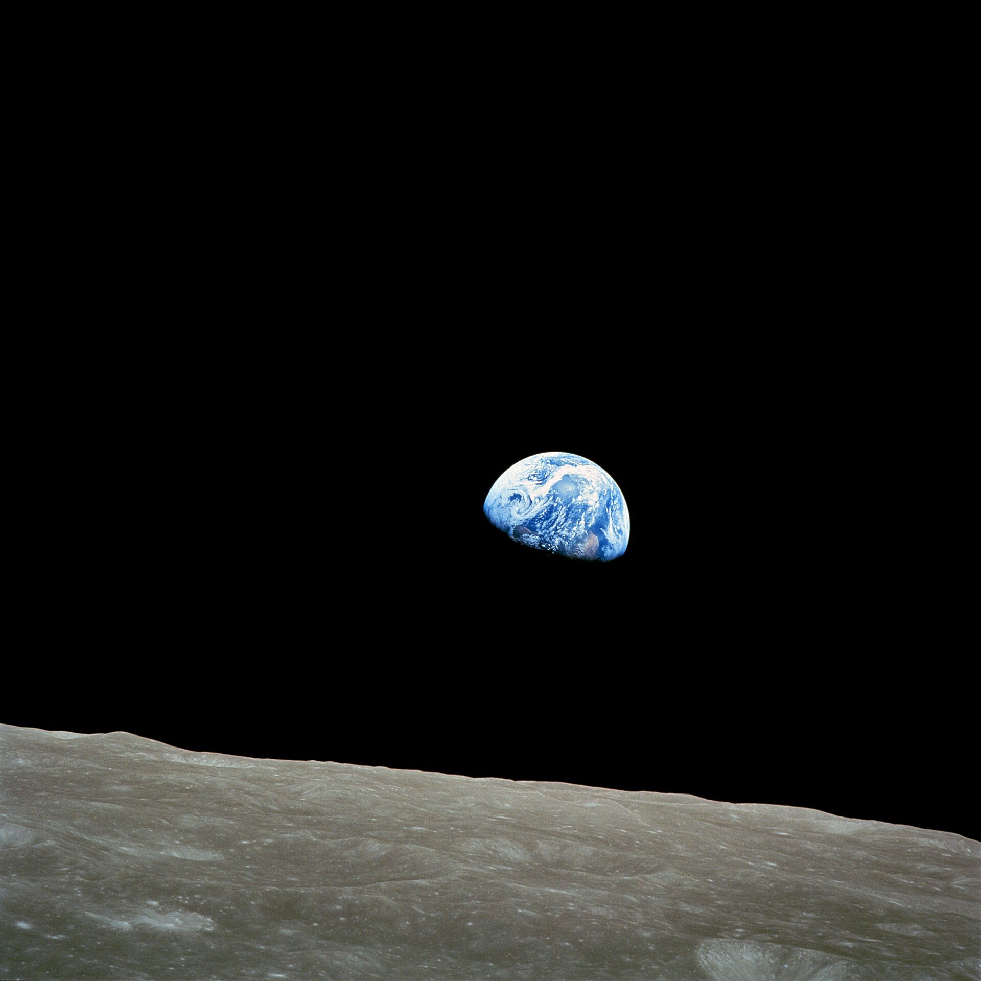 Earth rises above the grey lunar horizon in the Apollo 8 Earthrise photograph.